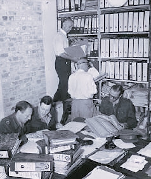 People in a room with binders and books